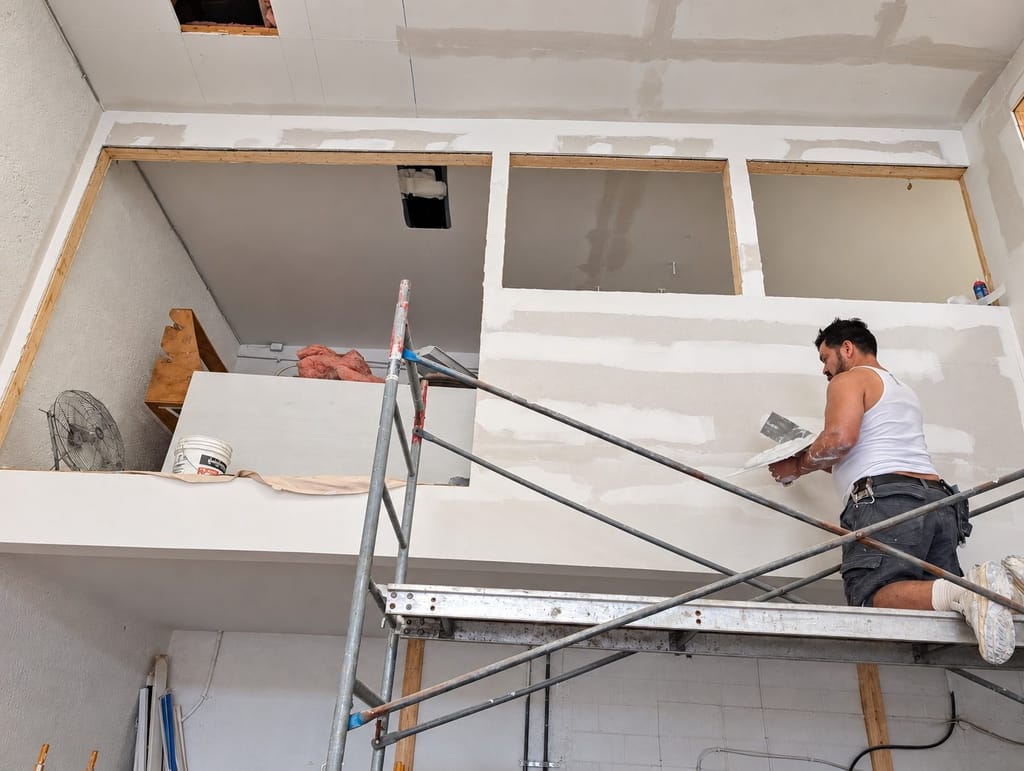 Pose du gypse sur échafaudage par l'équipe d'ASA, sur un chantier clé en main.