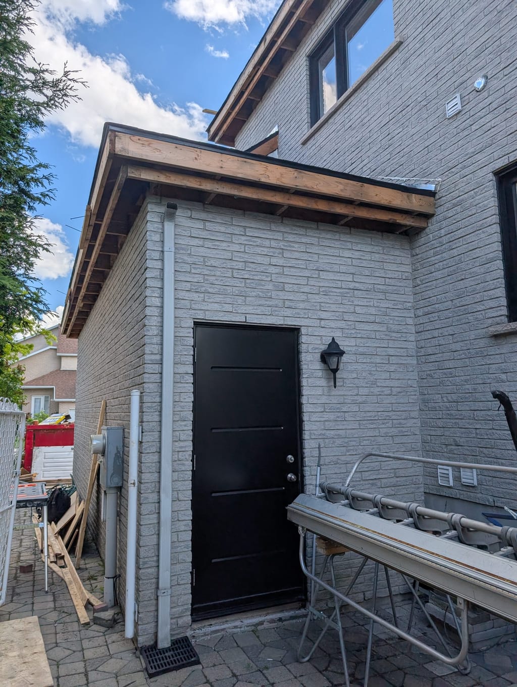 Annexe de brique et porte noire ajoutées à une maison existante par ASA.