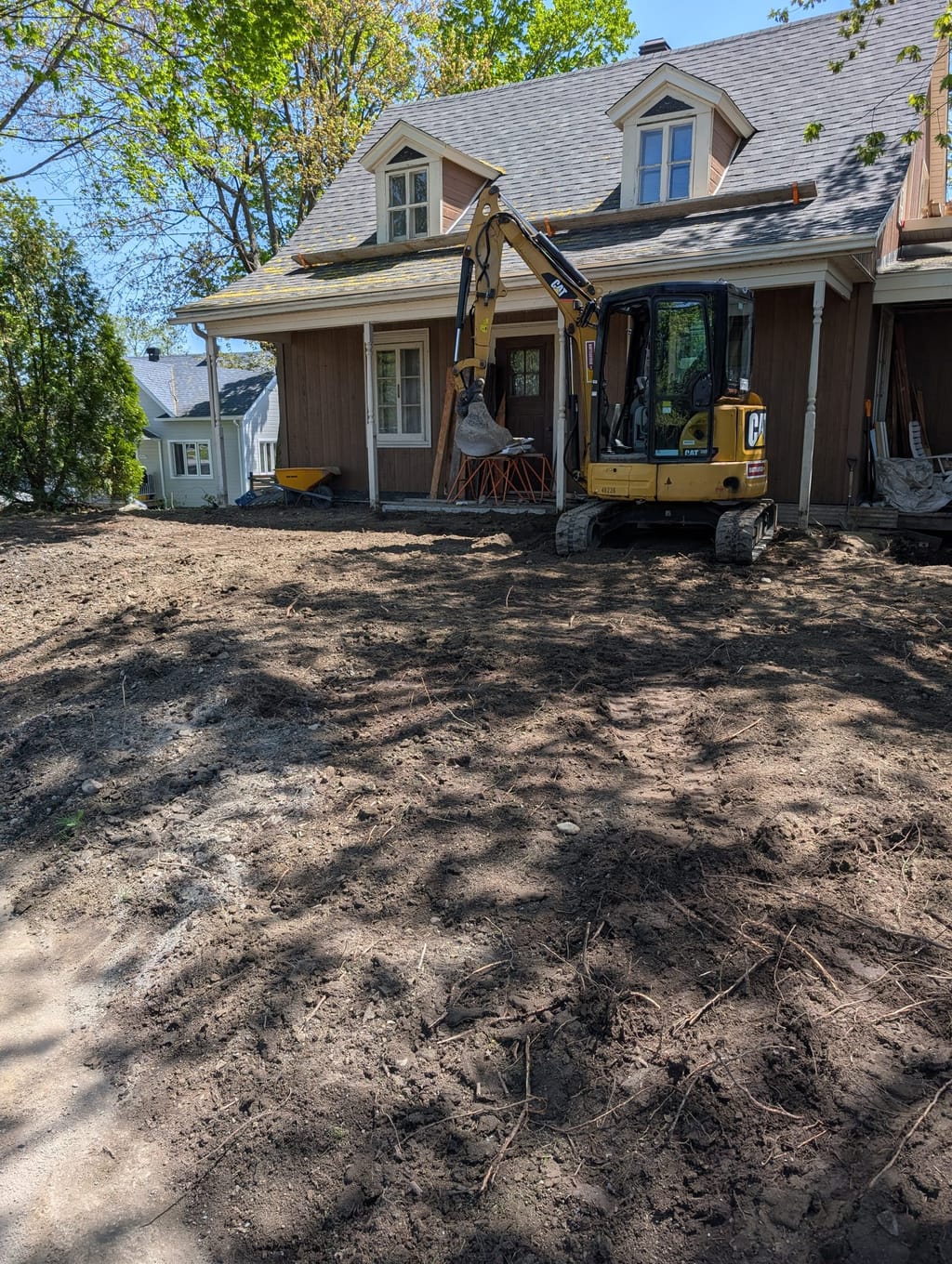 Excavation en cour avant pour la reprise du drainage d'une fondation.