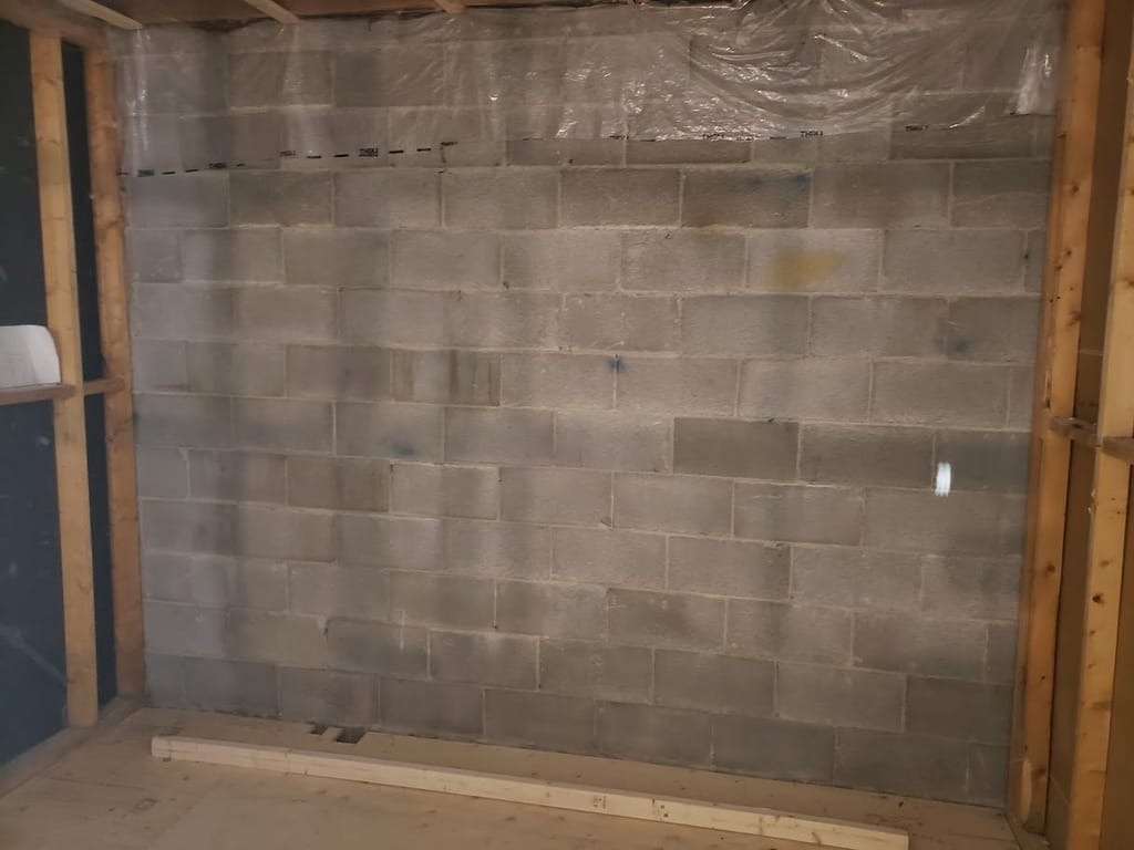 Mur de béton d'un sous-sol avant les travaux : c'est ici qu'on regarde en premier.