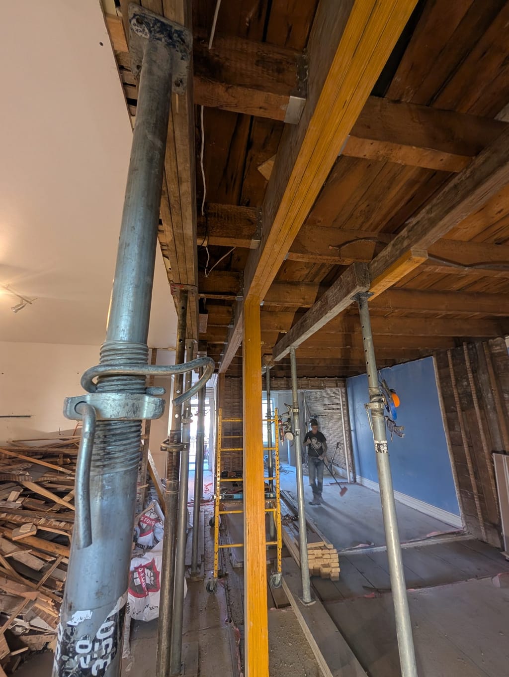 Poteau d'acier et poutre de bois installés selon les plans scellés, avant la refermeture.